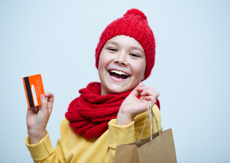 Shopping, sale, holiday concept - smiling girl with shopping bags and plastic cardの写真素材