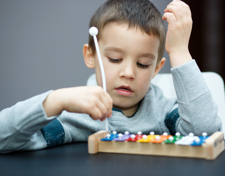 Cute little boy is playing a musical instrumentの写真素材