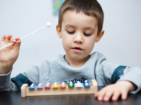 Cute little boy is playing a musical instrumentの写真素材