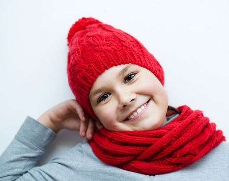 Cheerful smiling girl wearing a hat and scarfの写真素材