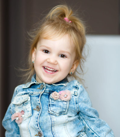 Portrait of a happy little girl raising her hands up