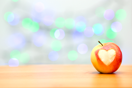 red apple in the form of heart on a wooden backgroundの写真素材