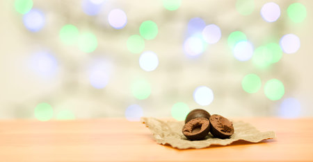 Chocolate sweets on wooden and color lights background