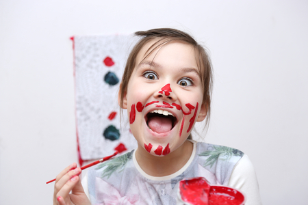 Cute girl showing her hands painted in bright colorsの写真素材