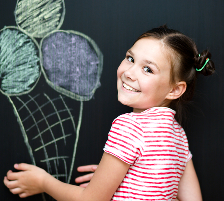 Cute happy girl is eating ice-cream. On a black backgroundの写真素材