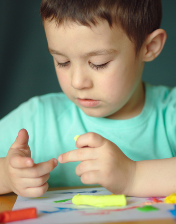 Happy boy playing with color play doughの写真素材