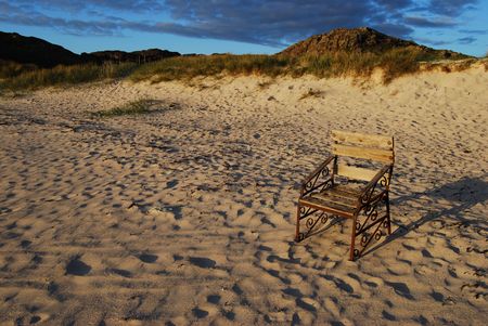 a chair standing on a beach facing the seaの写真素材