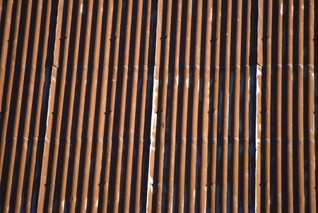 detail of an old red corrugated iron roofの写真素材