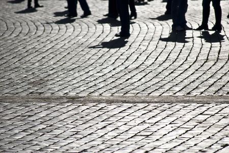 peolpe walking along an old road made of cobblestonesの写真素材