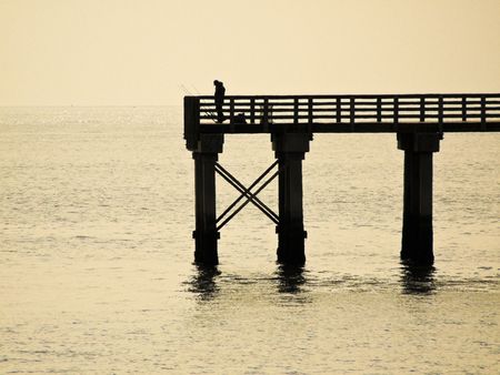 Man standing on the pier in Coney Island spending his leisure time with fishingの写真素材