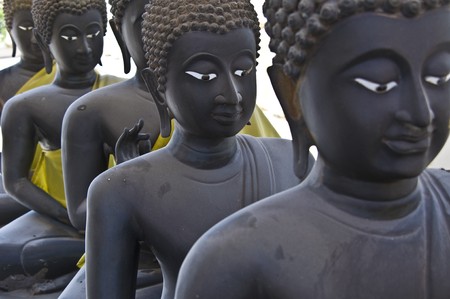 lots of statues of buddha sitting in linesの写真素材