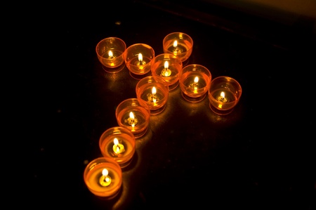 burning candles in the shape of a crossの写真素材