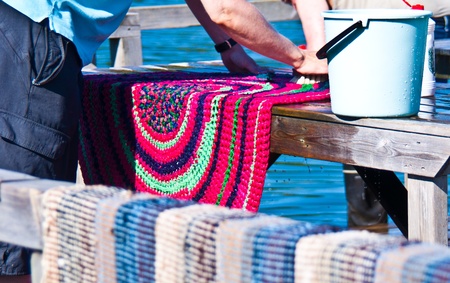 man washing his carpet at a station in Helsinkiのeditorial素材