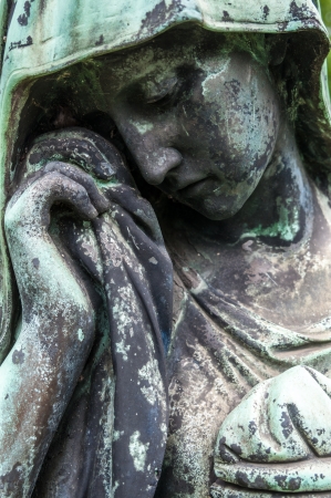 detail of a mourning sculpture on a cemeteryの写真素材