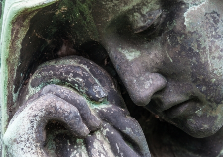 detail of a mourning sculpture on a cemeteryの写真素材