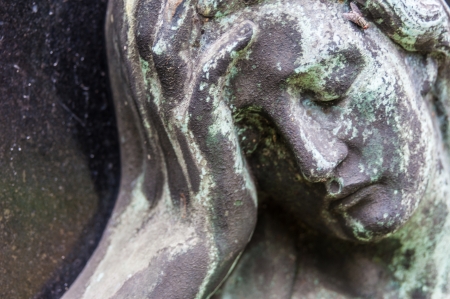 detail of a mourning sculpture on a cemeteryの写真素材
