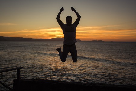 Model jumping with amazing back lighting sunset behindの写真素材