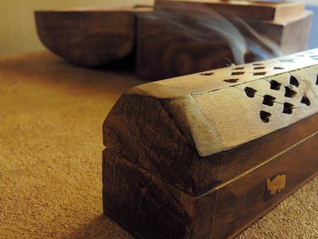 Incense box on a rustic table with a trunk of wood.の写真素材