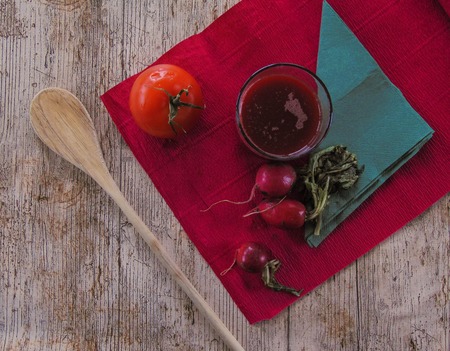 Radish juice with tomato on a pink background next to a green napkin.の写真素材