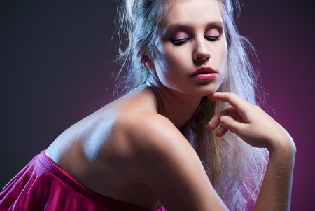portrait of beautiful fashionable woman with beautiful makeup on dark pink backgroundの写真素材