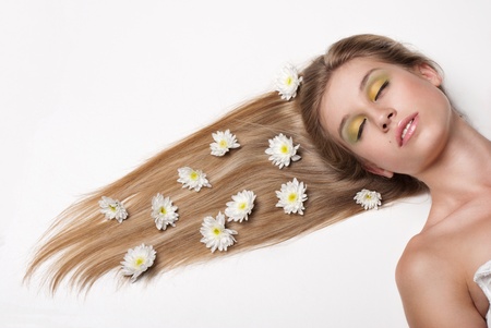 attractive young woman lying covered with flowers の写真素材