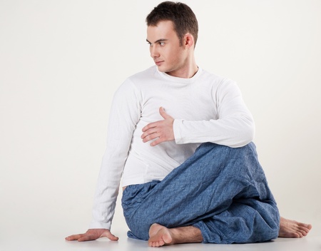 Portrait of healthy young man doing yoga - Spine twisting poseの写真素材