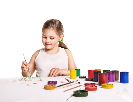 small beautiful girl paints on paper over white backgroundの写真素材