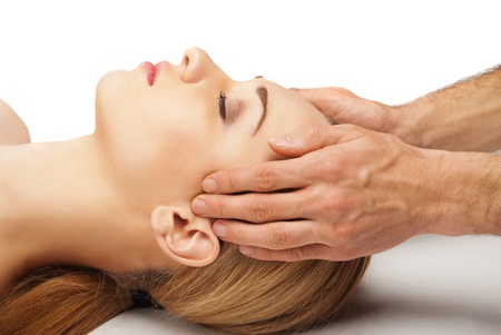 Young bright woman receiving a head massage in a spa centreの写真素材
