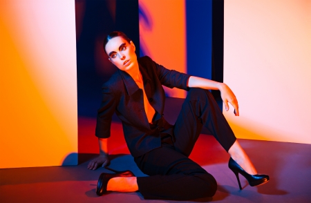 Fashion Portrait of beautiful woman wearing luxury suit and posing over colorful backgroundの写真素材
