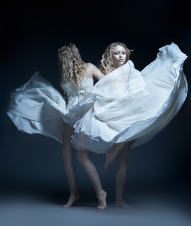 Fine art photo of a dancing beautiful young girl in white wedding dress with multiexpositionの写真素材