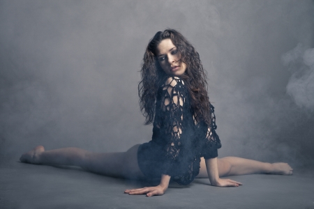Modern style dancer posing on a studio grey background in fogの写真素材