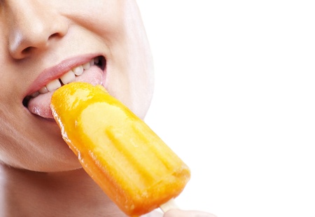 Portrait of sexy young beautiful woman eating orange sweet ice-cream and having funの写真素材