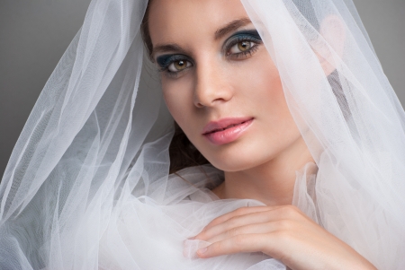 beautiful bride portrait with veil over her face, wearing professional make-upの写真素材