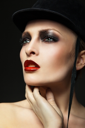 Blond fashion horsewoman wearing hat posing over black backgroundの写真素材