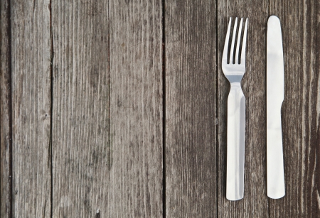 Knife and fork on old wooden tableの写真素材