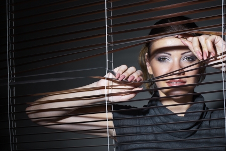 sexy woman in black dress with jalousieの写真素材