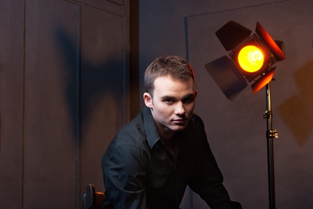 Closeup portrait of a sexy male model in studio on dark grey background with flashesの写真素材