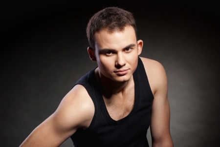 Closeup portrait of a sexy male model on dark grey backgroundの写真素材