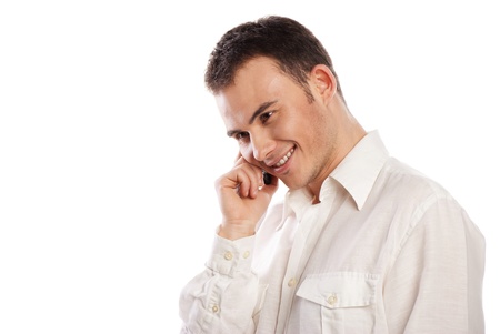 Young and healthy man smiling and talking on phone over white backgroundの写真素材