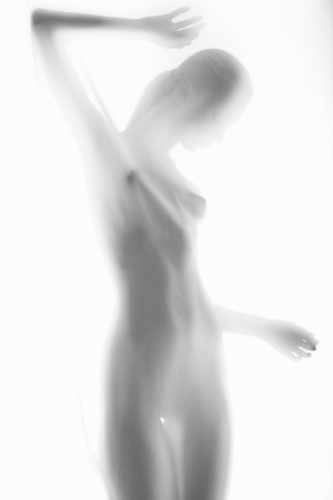 The body of a beautiful naked woman through the transparent fabric on a light backgroundの写真素材