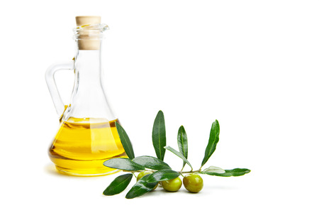 Glass bottle of virgin olive oil and branch with olives isolated on whiteの写真素材