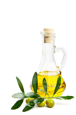 Glass bottle of virgin olive oil and branch with olives isolated on whiteの写真素材