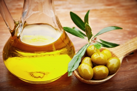 Extra virgin healthy Olive oil with fresh olives on rustic wooden backgroundの写真素材
