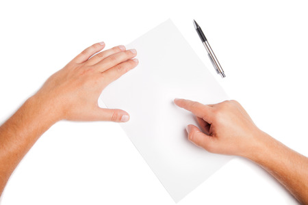 Close-up man hands pointing on white blank with pen Isolatedの写真素材