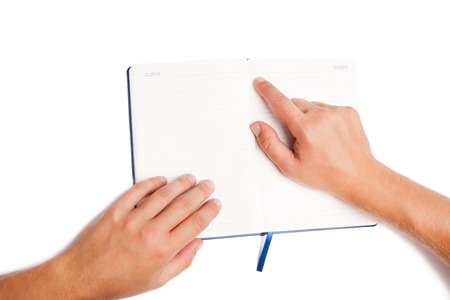 Man hand holding open book and pointing isolated on white backgroundの写真素材