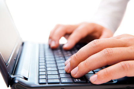 Close up of young businessman working on a laptop isolated on white backgroundの写真素材