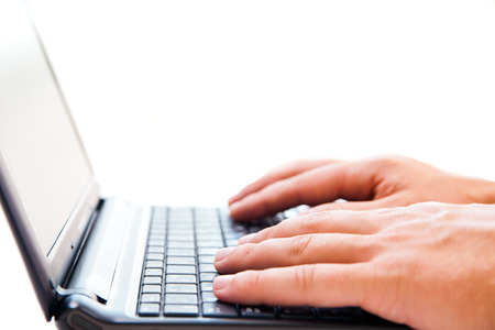 Close up of young businessman working on a laptop isolated on white backgroundの写真素材