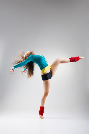 Modern style dancer posing on a studio grey backgroundの写真素材