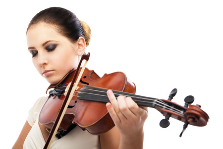 Beautiful young woman playing violin over white backgroundの写真素材