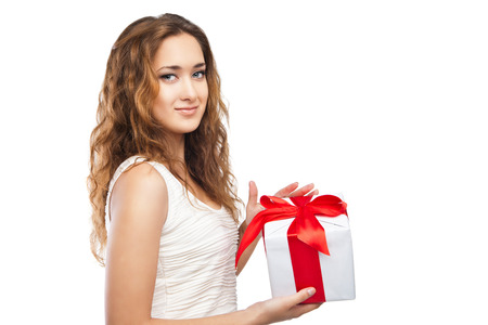 Beautiful young Christmas girl with a present isolated on white backgroundの写真素材